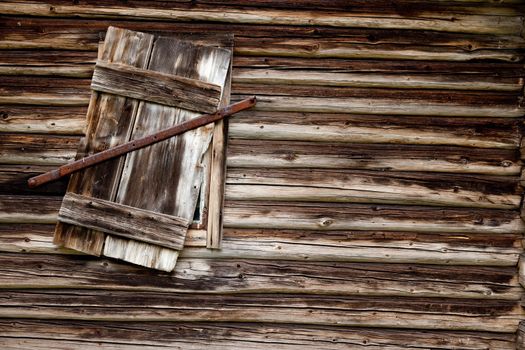 A weathered log cabin background texture with old window