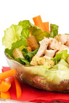 A bowl of chicken Caesar salad isolated on white