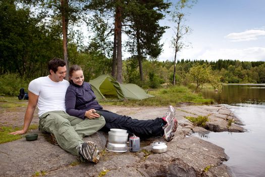 A couple camping and eating outdoors