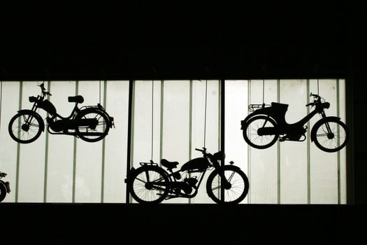 silhouettes of old motorbikes on the wall