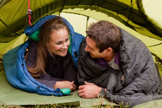 A happy couple in a tent looking at each other