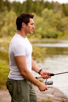 A young adult fishing on an interior fresh water forest lake