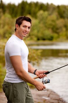 A man fishing on a inerior lake with forest in the background