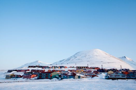 A detail of Longyearbyen, Svalbard, Norway.  A row of houses and a mountain in the distance.