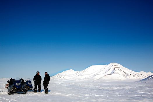 Two men on a snowmobile trip on Svalbard, Norway