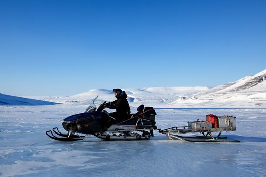 A man on a snowmobile against a winter landscape