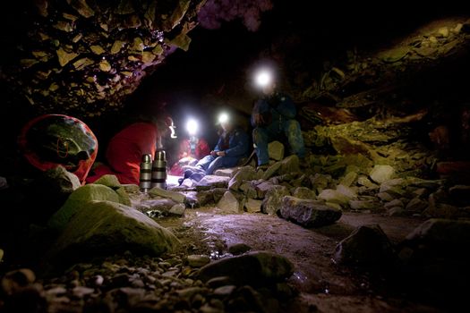 A group of people eating lunch in a dark cave