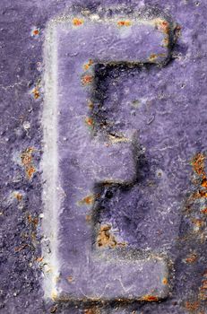 The letter E on a highly textured metallic violet surface
