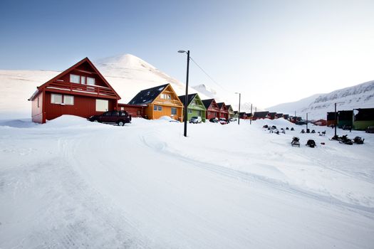 A detail of Longyearbyen, Svalbard, Norway.  A row of houses and a mountain in the distance.