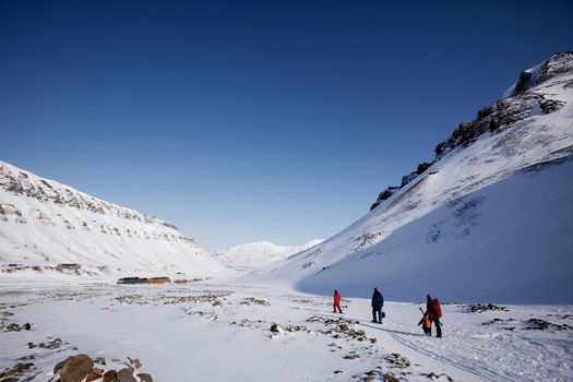 A group of people walking along a path ouside Longyearbyen, Spitsbergen, Svalbard, Norway