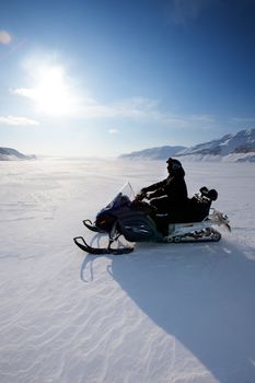 A snowmobile on frozen ice on a barren winter landscape