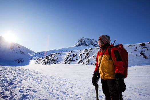 A female mountaineer against a winter mountain landscape