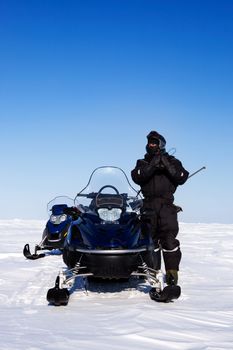 An expedition guide and a couple of snowmobiles on a winter landscape