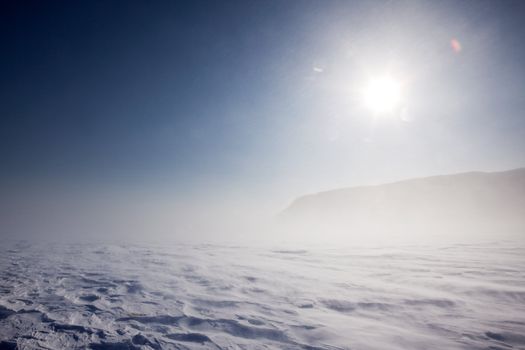 Blowing snow across a desolate winter landscape