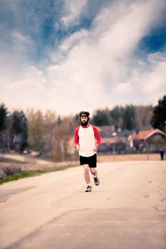 A runner with long hair and beard jogging in the country - Retro style image