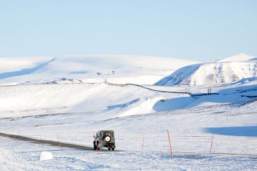 A truck driving on a barren landscape of snow and ice - Svalbard, Norway