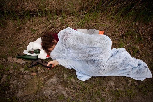 A drunk homeless man sleeping in a ditch