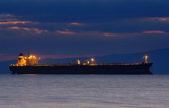 Image of an illuminated merchant ship at dusk