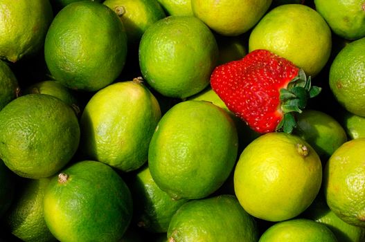 Image shows a pattern of lemons with a sole strawberry among them