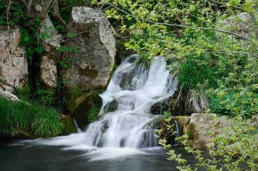 Image shows a small waterfall in a European forest