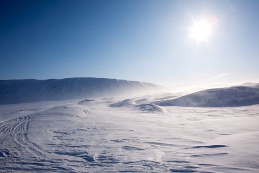 Blowing snow in a barren winter mountain landscape