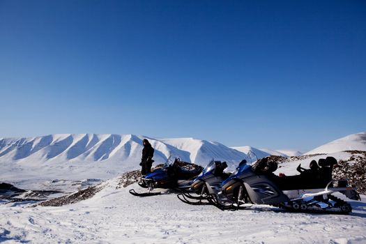 Snowmobiles in a barren winter landscape, Svalbard, Norway