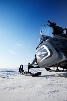 A snowmobile detail on a barren winter landscape