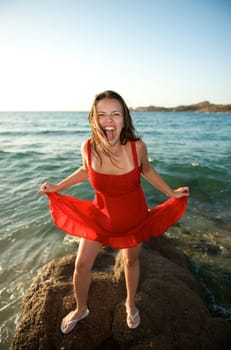 Pretty girl screaming on the beach during her vacation