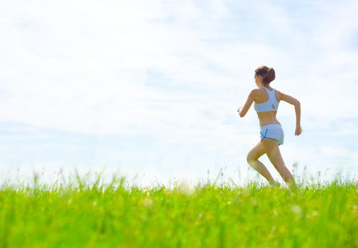 Mature woman athlete practicing in a spring meadow, from a complete series.