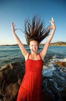 Pretty girl moving her hair on the beach at sunset time