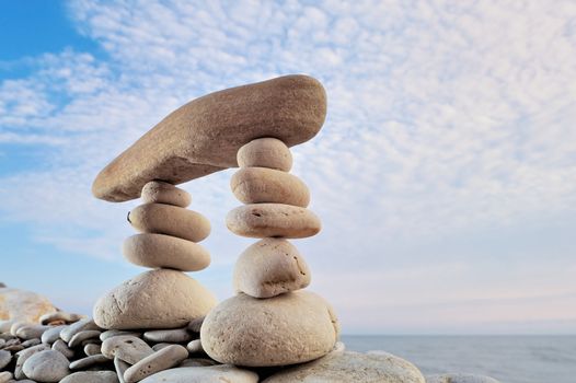 Long horizontal stone is between a stack of pebbles