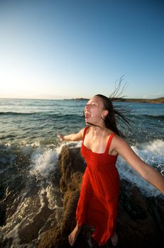 Pretty girl moving her hair on the beach at sunset time