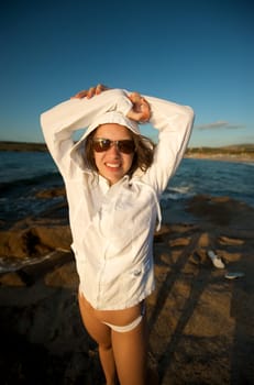 Wonderful pretty girl wearing a bikini posing on the beach at sunset time