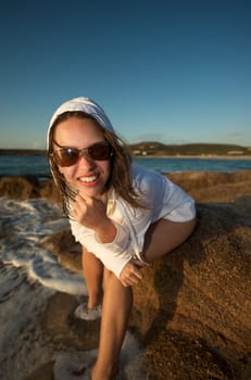 Wonderful pretty girl wearing a bikini posing on the beach at sunset time