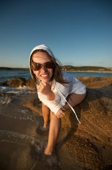 Wonderful pretty girl wearing a bikini posing on the beach at sunset time