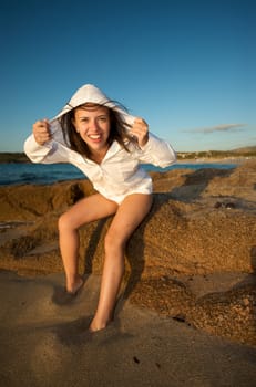 Wonderful pretty girl wearing a bikini posing on the beach at sunset time