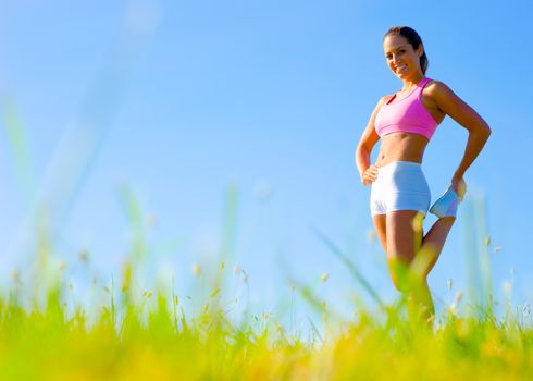 Athletic woman working out in a meadow, from a complete series of photos.