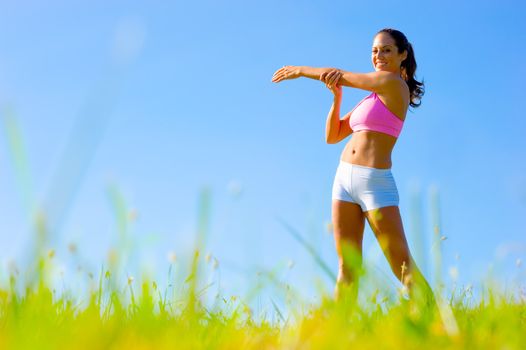 Athletic woman working out in a meadow, from a complete series of photos.