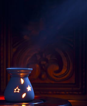 A smoking oil incense on a wooden background