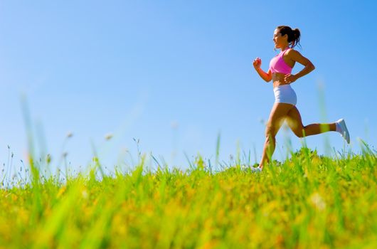 Athletic woman working out in a meadow, from a complete series of photos.