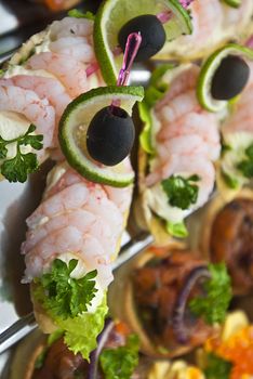 Shrimps with lemon and olives served on plate