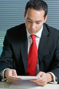 Smart eurasian business man in formal attire working and browsing with documents