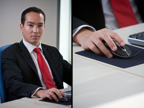Handsome asian chinese business man using computer holding the mouse