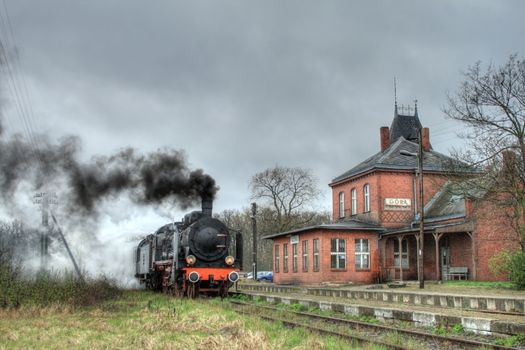 Old retro steam train stopped at the small station
