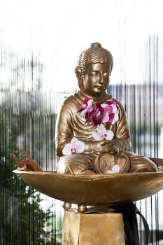  buddha statue in front off a window