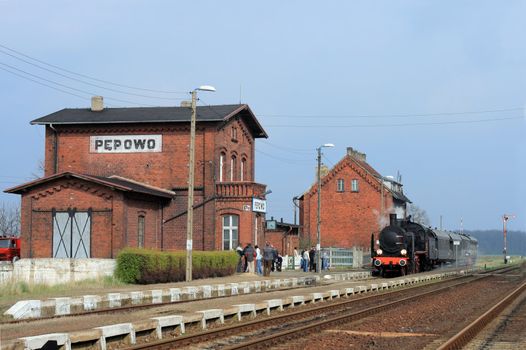 Old retro steam train stopped at the small station
