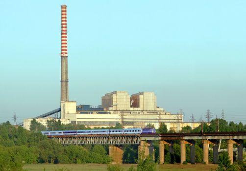 Industrial landscape with a intercity train and power plant
