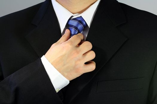 Businessman tying up his tie