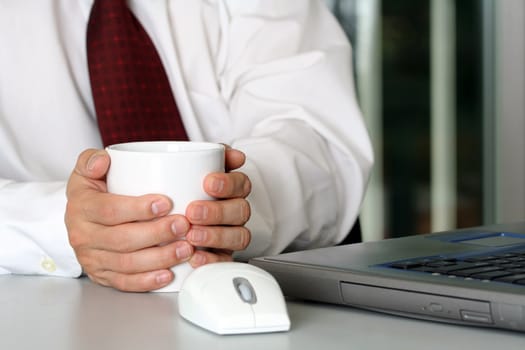 Businessman with a cup of coffee and laptop