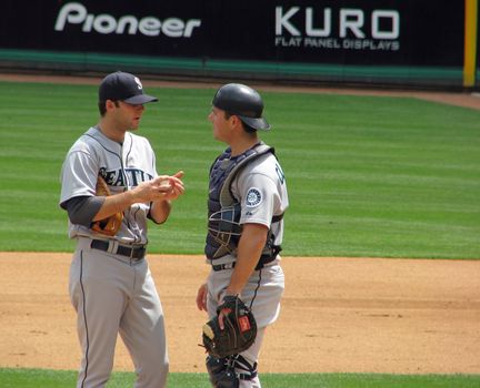 The Seattle Mariners pitcher and catcher have a conference on the pitcher's mound.